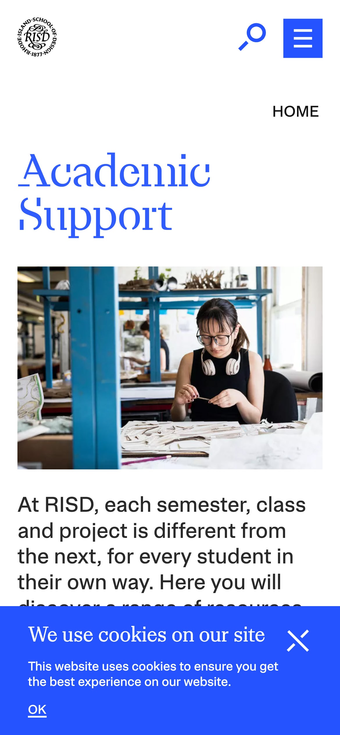 RISD Academic Support page with a cookie consent banner at the bottom and a student working on art projects in the background.